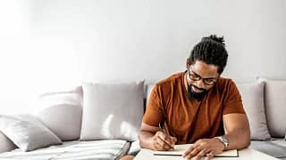 man on couch writing in notebook YuEdzZp.width .jpg