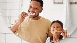 Adult and child brushing their teeth in front.width .jpg