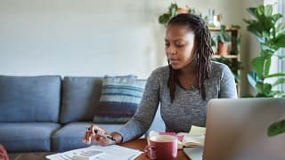 Woman making calculations as she uses her lap.width xufh.jpg