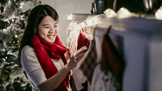 Woman hanging Christmas stocking over firepla.width .jpg