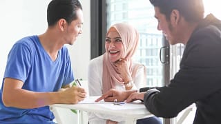 Young couple signs paperwork with agent TTMv.width .jpg