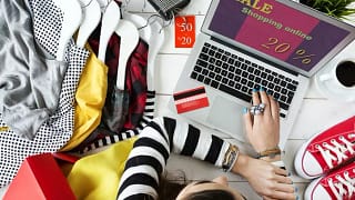woman online shopping on laptop with clothes .width .jpg