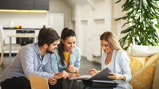 Couple signing paperwork with realtor.width .jpg