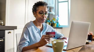 Mature woman hold credit card thoughtfully wh.width yPgZIJ.jpg