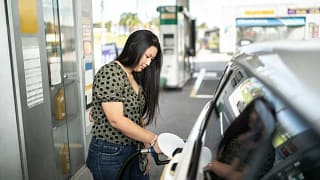 Woman refueling her car at a gas station tn.width .jpg