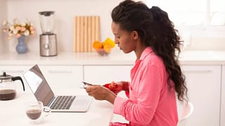 Woman sitting in front of her laptop cutting .width GXFCLY.jpg