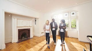 couple with realtor in empty living room.width .jpg