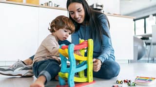 Mother and young son play with car toys toget.width .jpg
