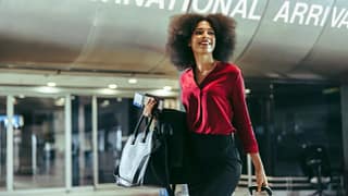Smiling traveler walks through airport with l.width .jpg