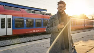 man with suitcase in front of train.width .jpg