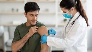 Healthcare worker putting bandaid over vaccin.width .jpg