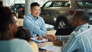 Salesman and customer shaking hands over pape.width .jpg