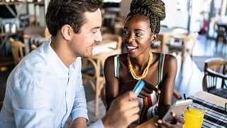 Couple has card out to pay in a restaurant. u.width .jpg
