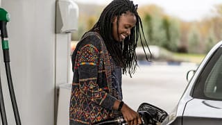Person smiling while pumping fuel into vehicl.width .jpg