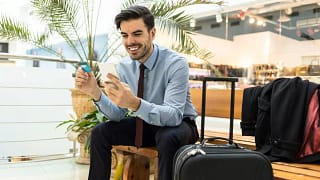 Traveler at airport with luggage phone and cr.width .jpg