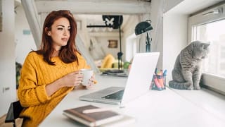 YoungWomanWithCatLookingAtLaptop.width scTOOW.jpg