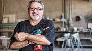 getty smiling happy workers with tool drill blue collar.jpg