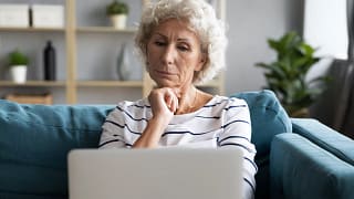 person with hand on chin looking at laptop.jpg