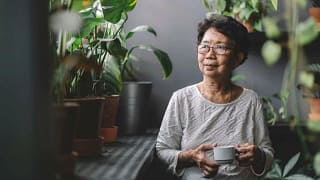 woman drinking tea near houseplants rpwlRul.width .jpg