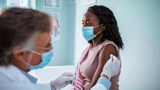 Masked woman receiving injection in her arm A.width .jpg