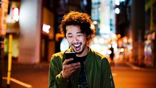 happy young man with smart phone at night.jpg
