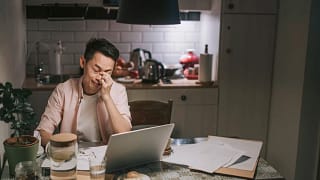 man with worried look in front of laptop .jpg