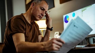 middle aged man serious looking at documents.jpg