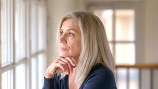 older person with serious expression looking out a window.jpg