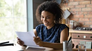 person smiling while opening mail eXwbW.width .jpg