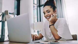 smiling young person with hand on chin looking at laptop.jpg