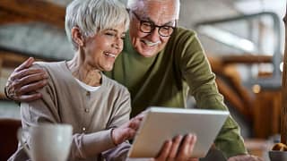 smiling couple looking at tablet together.jpg