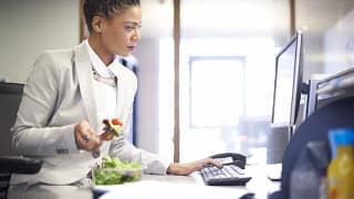 woman eating salad at work rCJmRBb.width .jpg