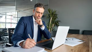man s biz suit desk taking notes gettyimages .jpg