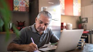 person sitting in front of laptop writing note.jpg
