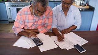 two people looking at documents and a calculator.jpg