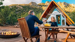 couple toasting over table outside house.jpg