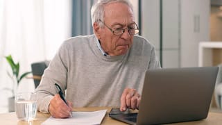 person looking at laptop and writing note.jpg