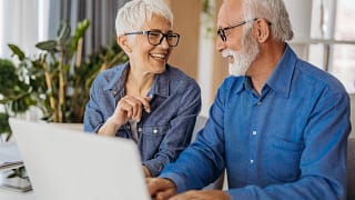 senior couple at laptop smiling gettyimages .jpg