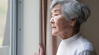senior woman looking outside care facility.jpg