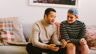 smiling couple discussing something on smartphone.jpg