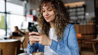 smiling person looking at smartphone in coffee shop.jpg