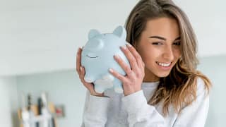 smiling person shaking piggy bank.jpg