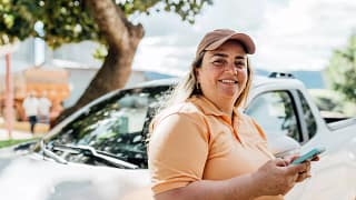 getty someone is standing by a car smiling.jpg