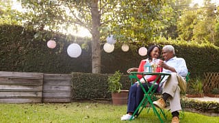 mature couple relaxing drinking wine together in their backyard.jpg