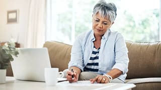 person holding pen and looking at document on coffee table.jpg