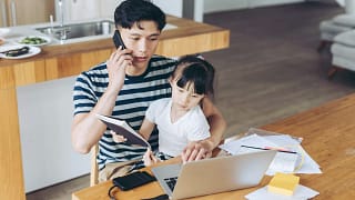 person talking on phone and looking at laptop with child on lap.jpg