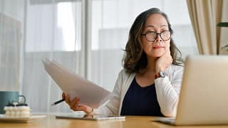 senior holding documents and looking at computer.jpg