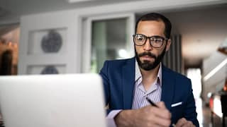 serious person staring at laptop and writing note.jpg