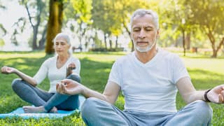 getty two people doing yoga or meditating outside health exercise.jpg