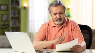 mature person holding pen and looking at document.jpg